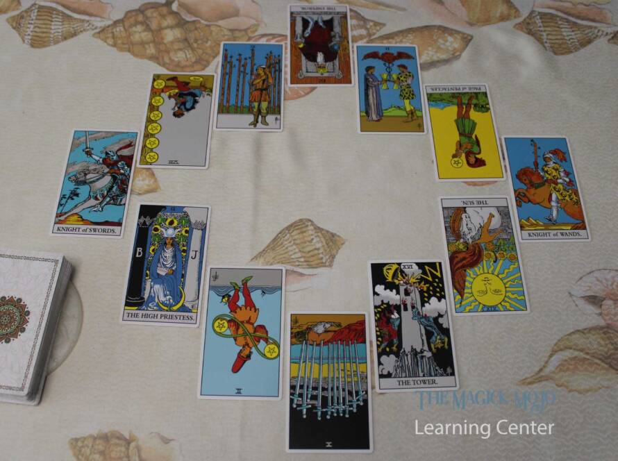 Tarot spread with twelve cards arranged in a circle on a shell-patterned background.