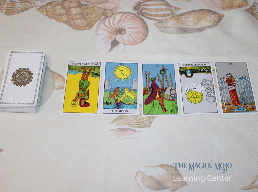 Tarot cards arranged in a straight line on a shell-patterned background