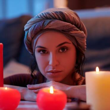 Tranquil soothsayer contemplating the candlelight before a magic ritual