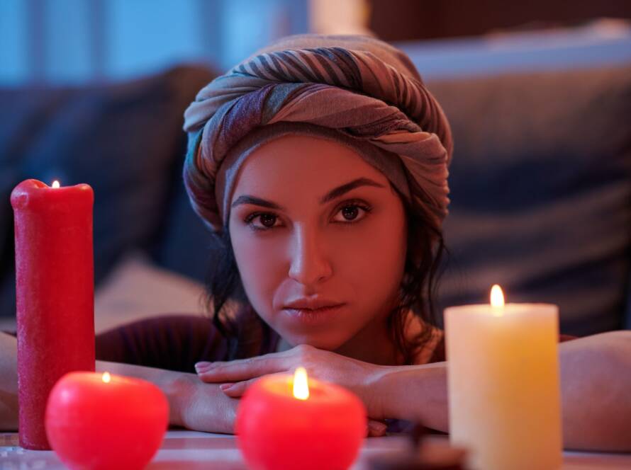 Tranquil soothsayer contemplating the candlelight before a magic ritual