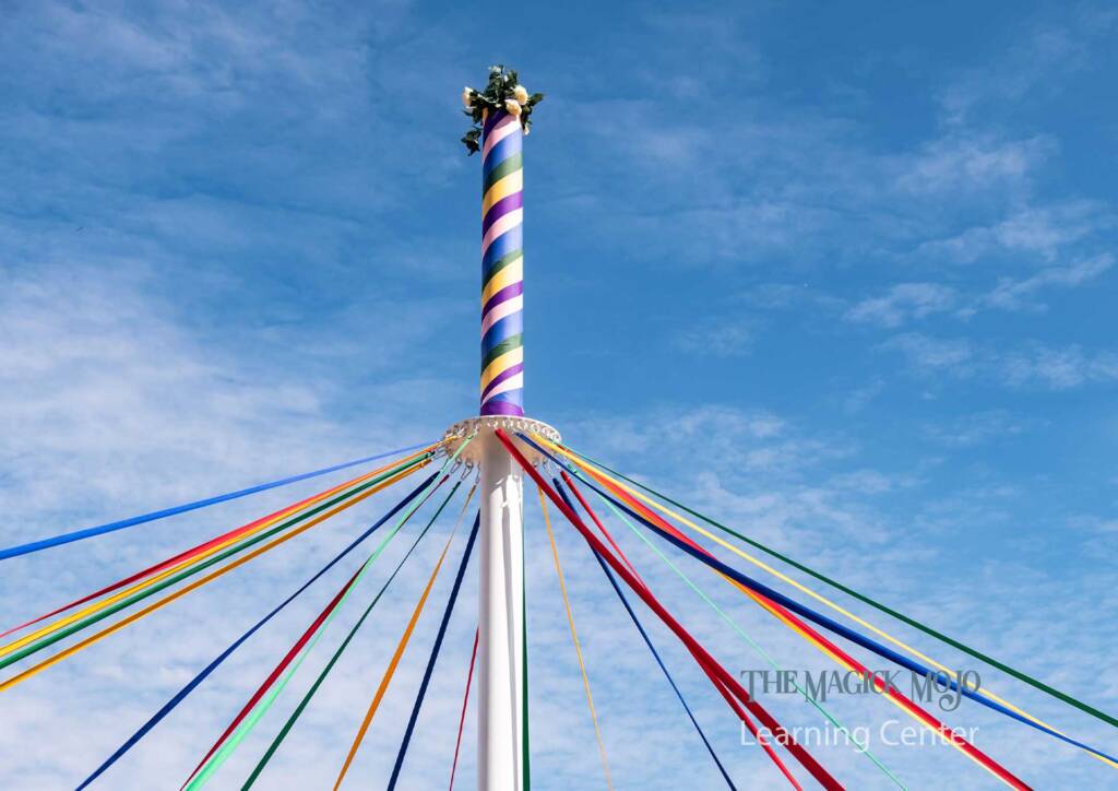 Colorful ribbons streaming from a Maypole during a Beltane celebration