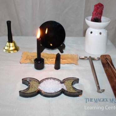 Return to Sender Spell altar setup with black mirror, candle, parchment, smudging herbs, sea salt, and black tourmaline