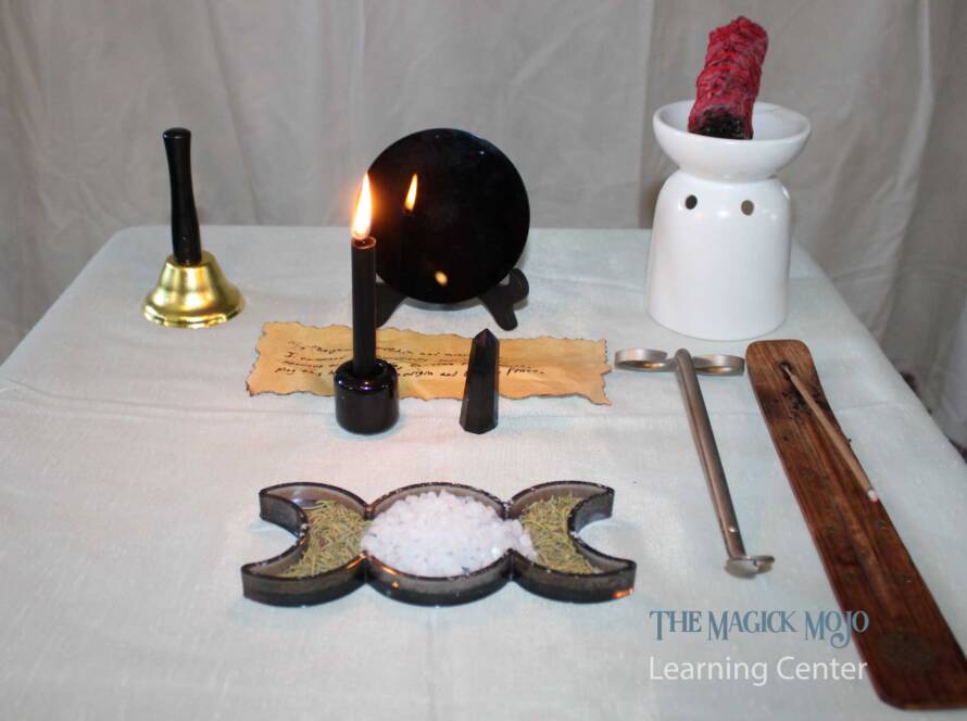 Return to Sender Spell altar setup with black mirror, candle, parchment, smudging herbs, sea salt, and black tourmaline