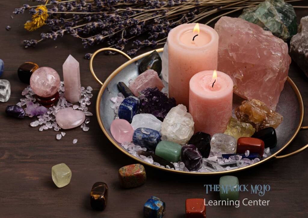 Candles and various crystals including rose quartz on a tray