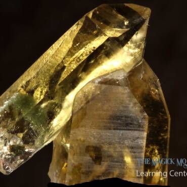Golden citrine crystal specimen with a dark background.