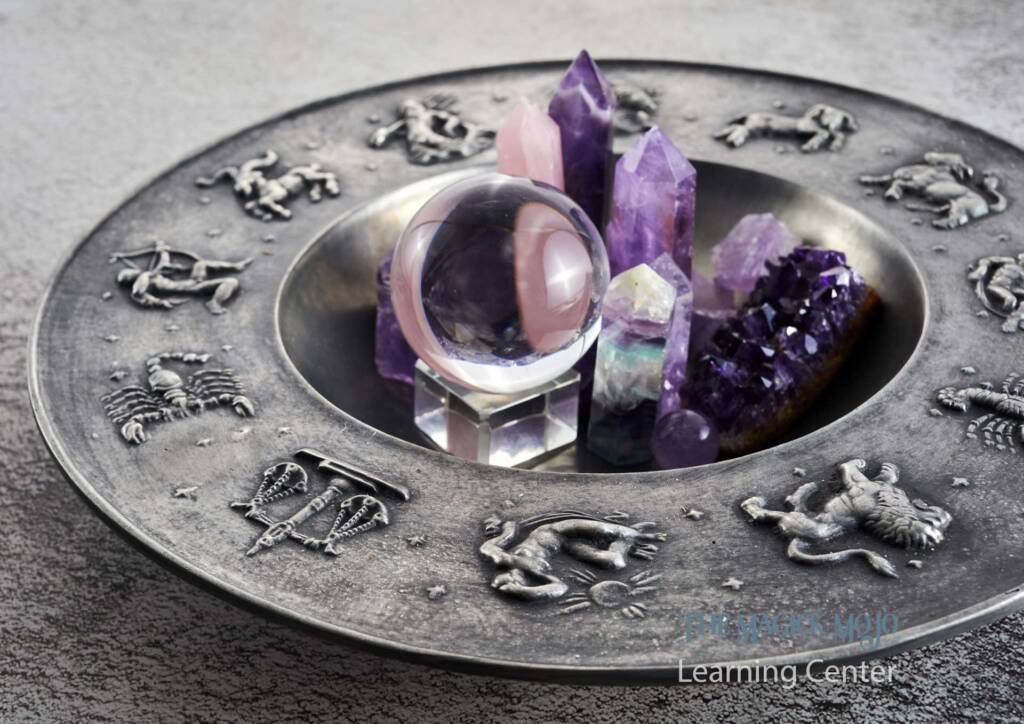 Amethyst crystals and a crystal ball on an astrological plate