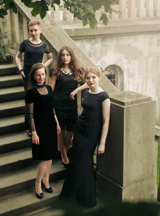 gorgeous luxury women in black dresses posing smiling on stairs under tree
